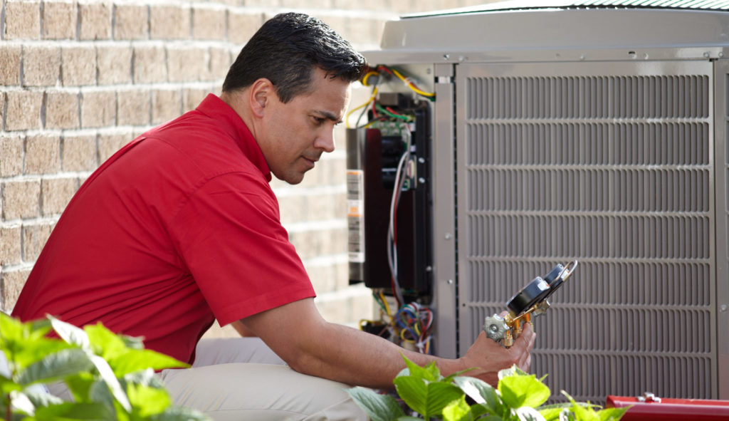 AIS technician servicing an air conditioner