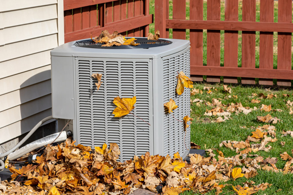 Dirty air conditioner covered in leaves