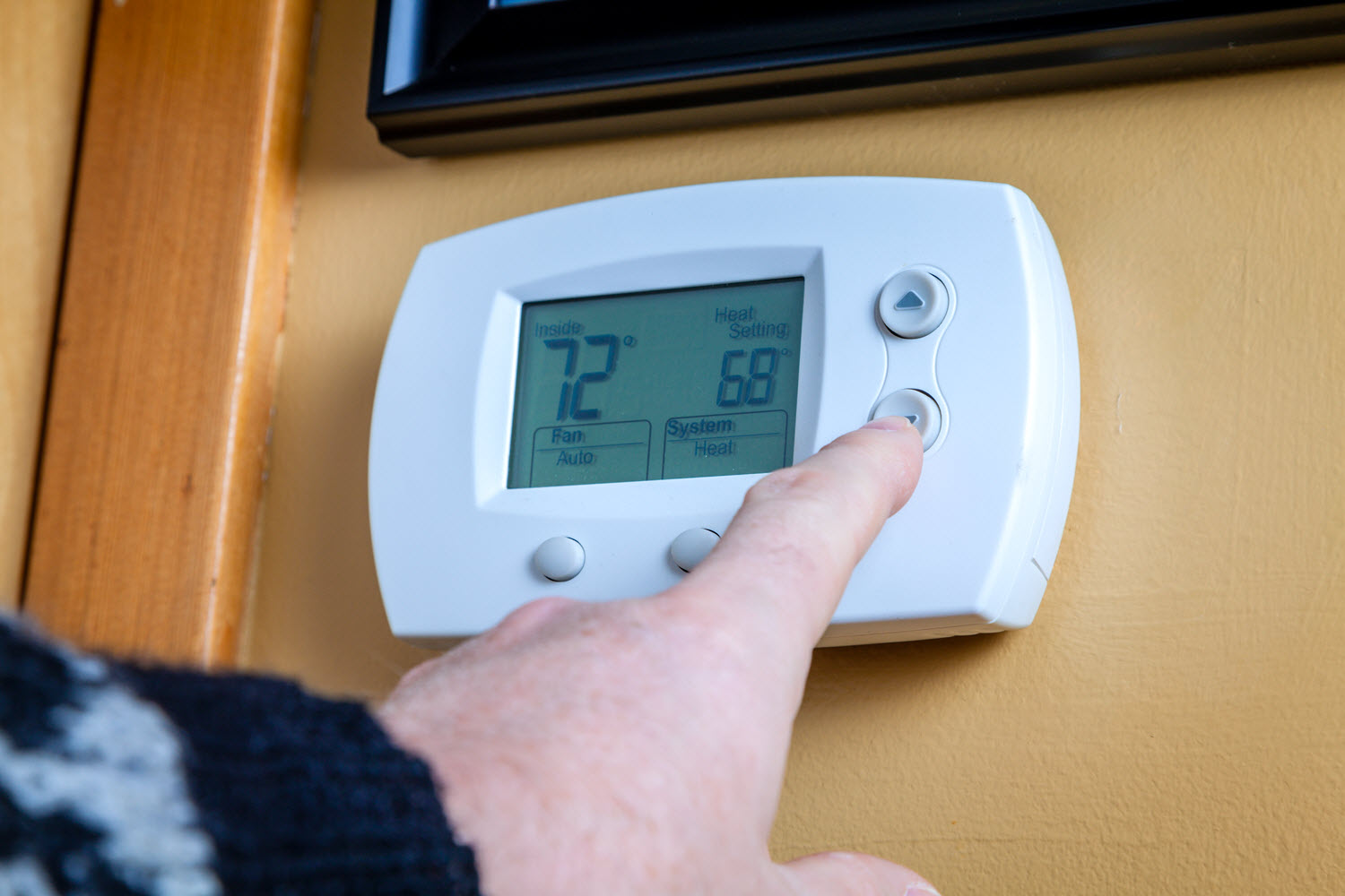 Hand on a thermostat